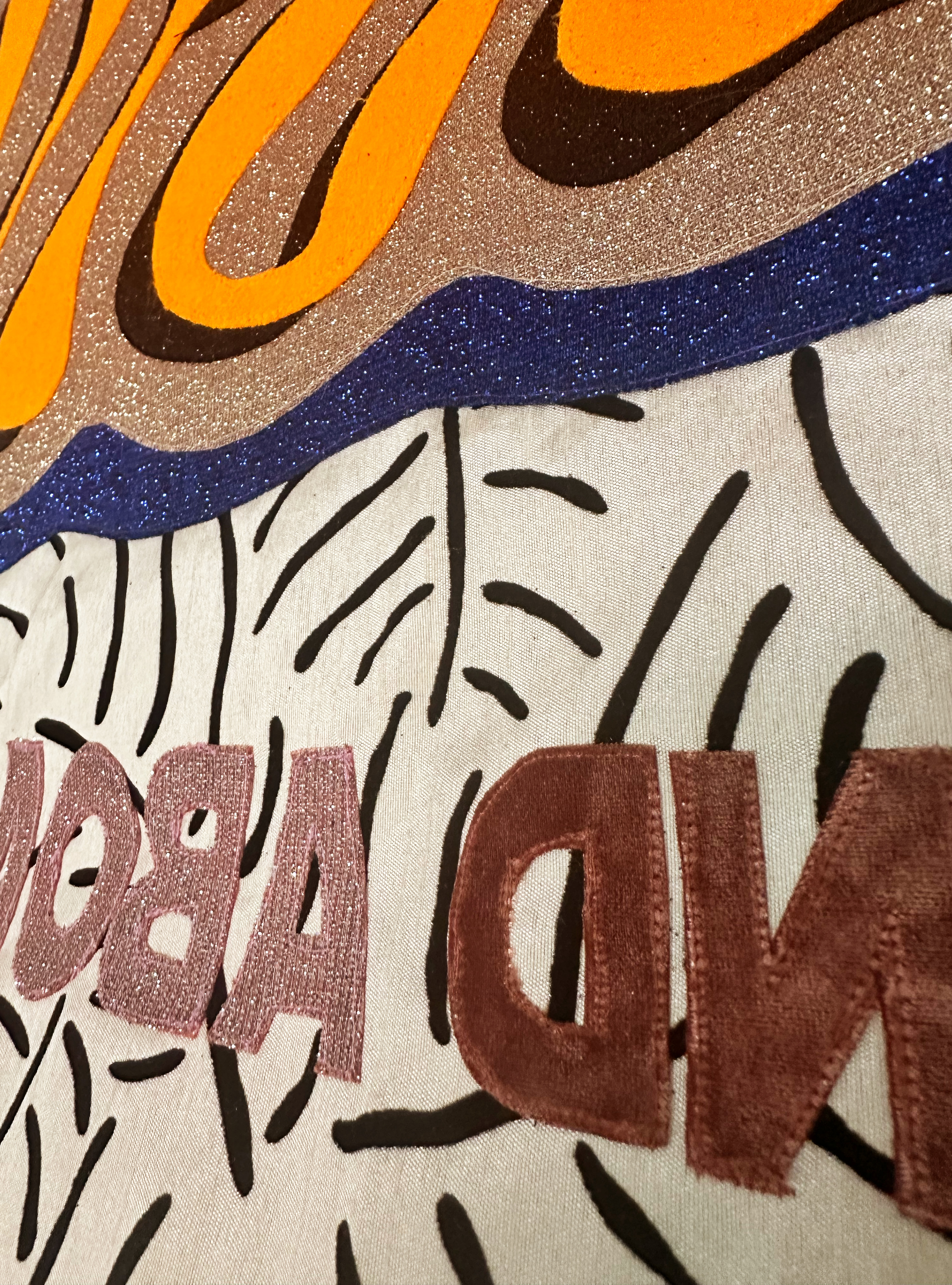 Closeup of the lettering on the textile artpiece from the previous image'