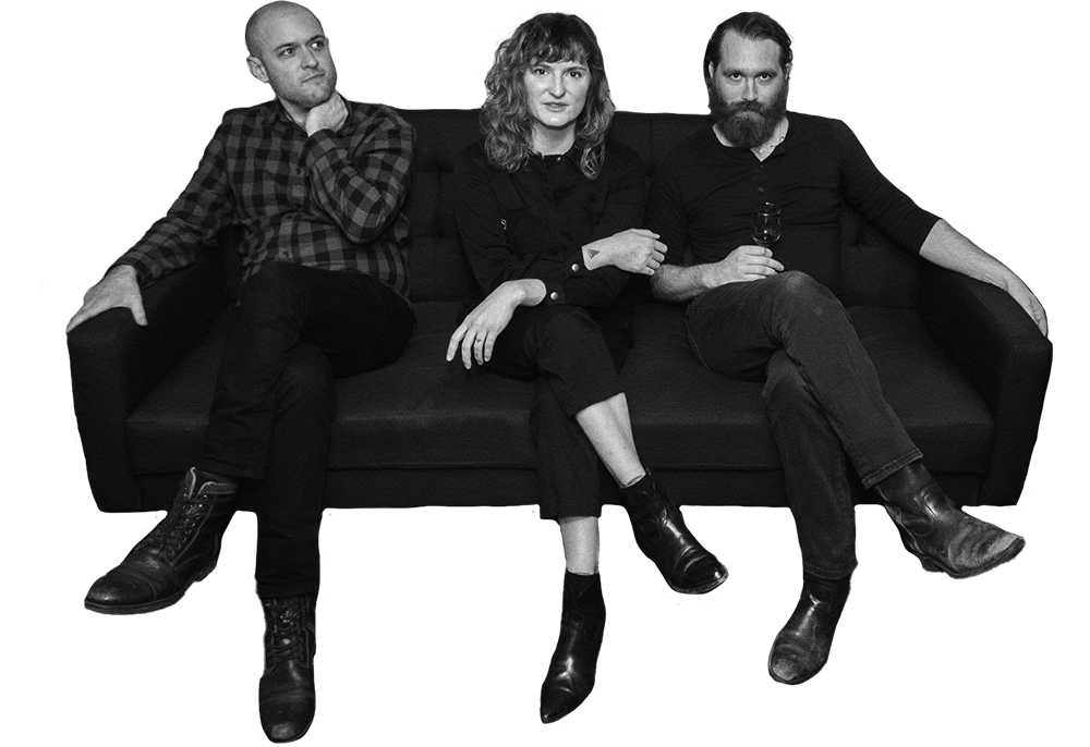 the trio Ouzelum sitting together on a couch, looking at the camera